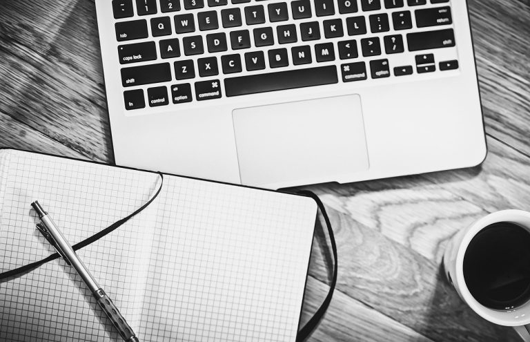 Computer, notebook, coffee — How Reinsurance Enhances Customer Loyalty and F&I Sales in Powersports Dealerships